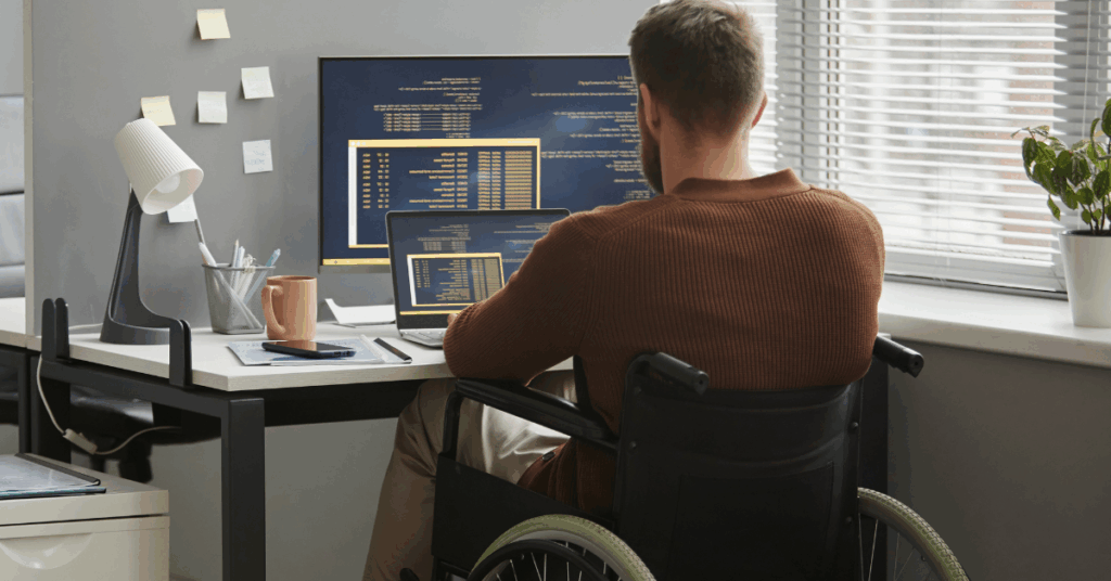 Entrepreneur using a wheelchair works from home on a computer, symbolizing strengths-based entrepreneurship and building a business that fits your life.